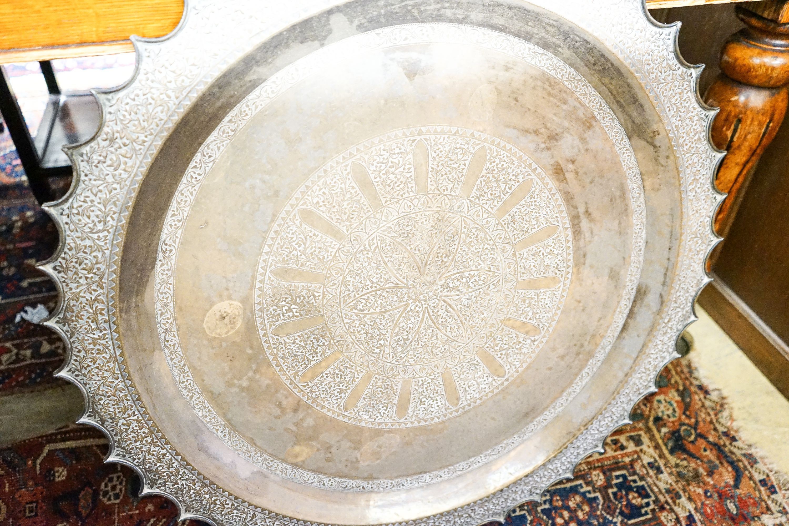 An Indian brass tray top table on folding stand, diameter 74cm, height 56cm together with a circular Indian brass tray